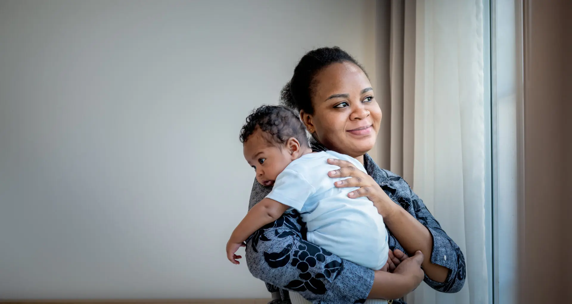 African family, 2-month-old baby newborn son is half-African halt-Thai on mother's shoulder,