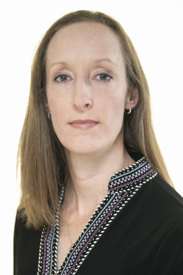 Woman with brown hair wearing a black top.