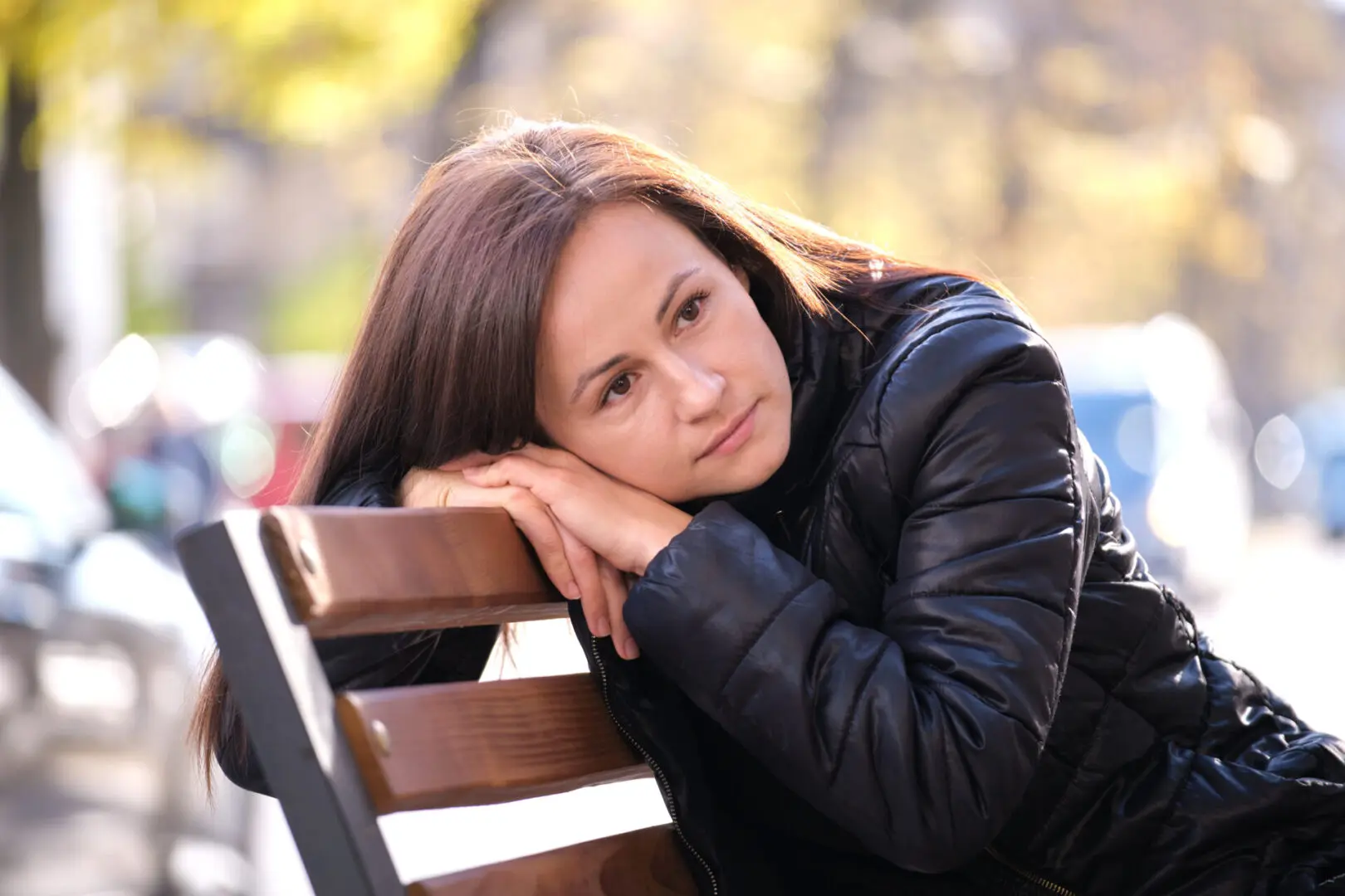 Young Sad Woman Sitting Alone On Street Bench Outdoors Thinking