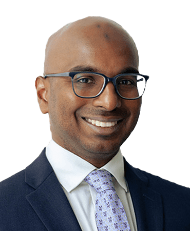 Smiling man in suit and glasses.