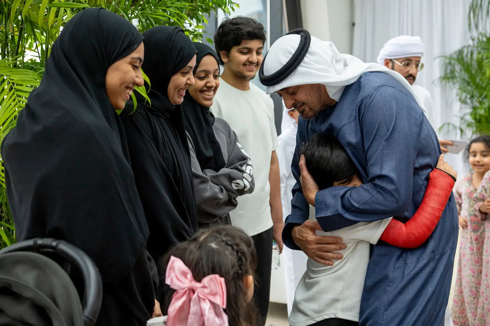 Man hugs child with arm in cast.