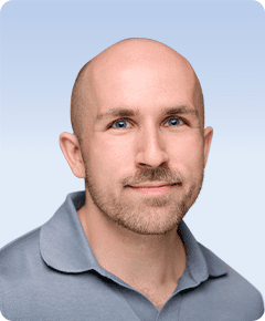Smiling man with a bald head.