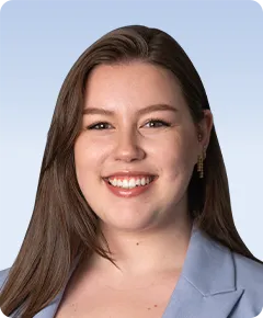 Smiling woman in blue blazer, brown hair.