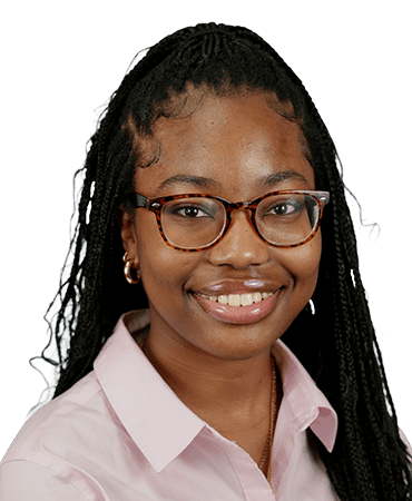 Young woman smiling, wearing glasses and braids.