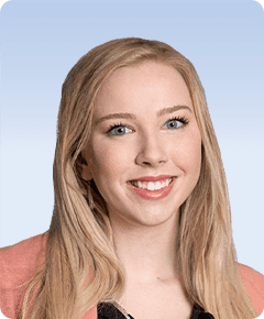 Smiling person with long blonde hair.