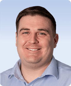 Smiling man in a light blue shirt.