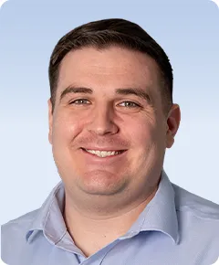 Smiling man in a light blue shirt.