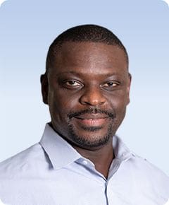 Man smiling in light blue shirt.