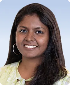 Smiling woman with long hair and earrings.