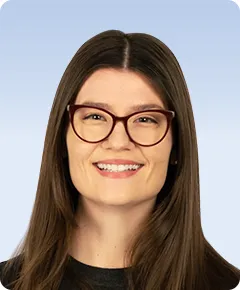 Smiling woman with glasses and long hair.