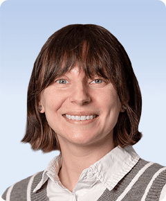 Smiling person with short hair and bangs.