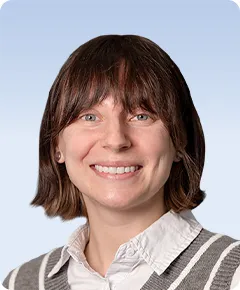 Smiling person with short brown hair.