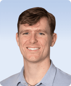 Smiling man in a light blue shirt.