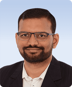 Man with glasses wearing a suit jacket.