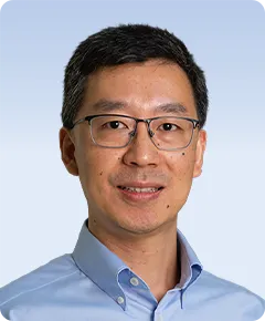 Man wearing glasses and blue shirt smiling.