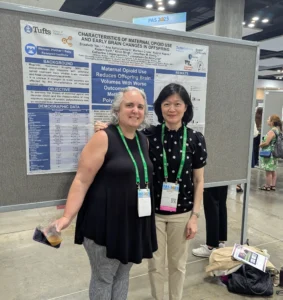Conference participants pose in front of poster