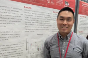 Smiling man standing in front of poster