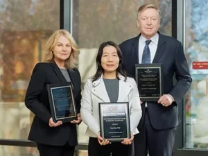 Group portrait of award recipients holding plaques