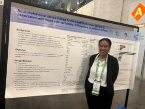 Woman with green lanyard beside poster