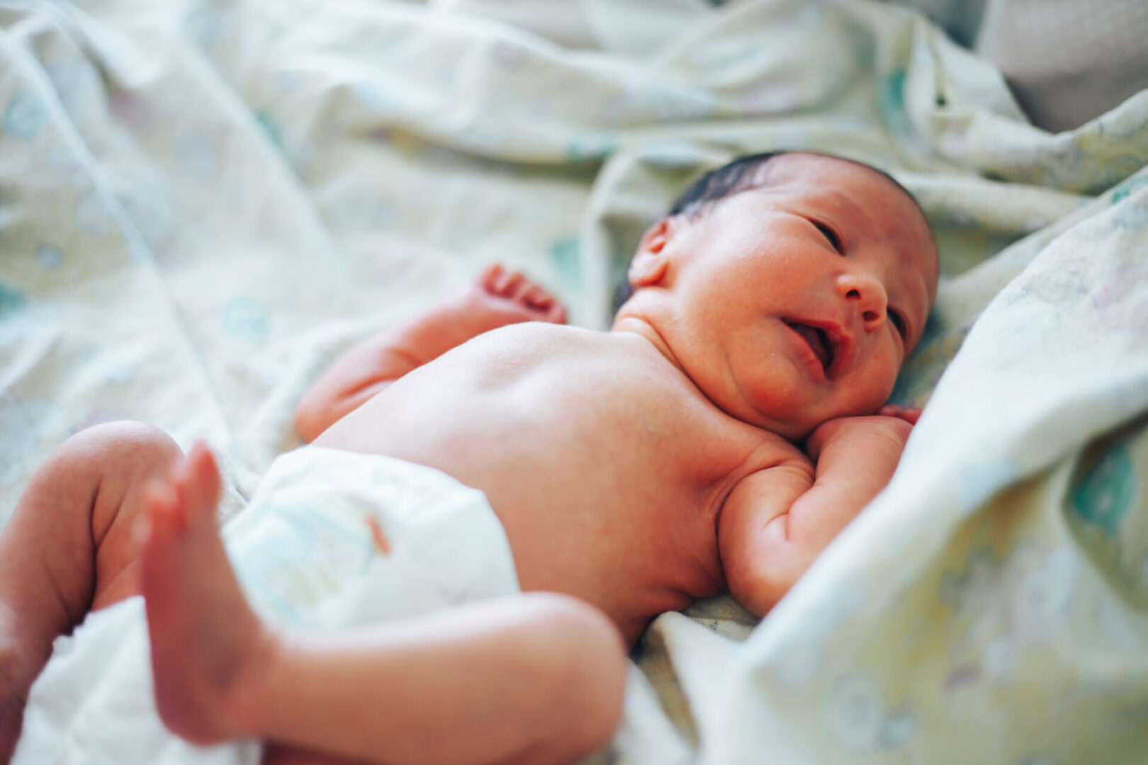 Newborn baby in hospital room. Infant sleeping in bedside bassinet. Little boy or girl