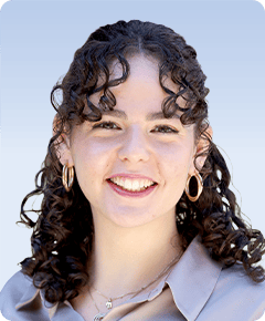Smiling person with curly hair and hoop earrings