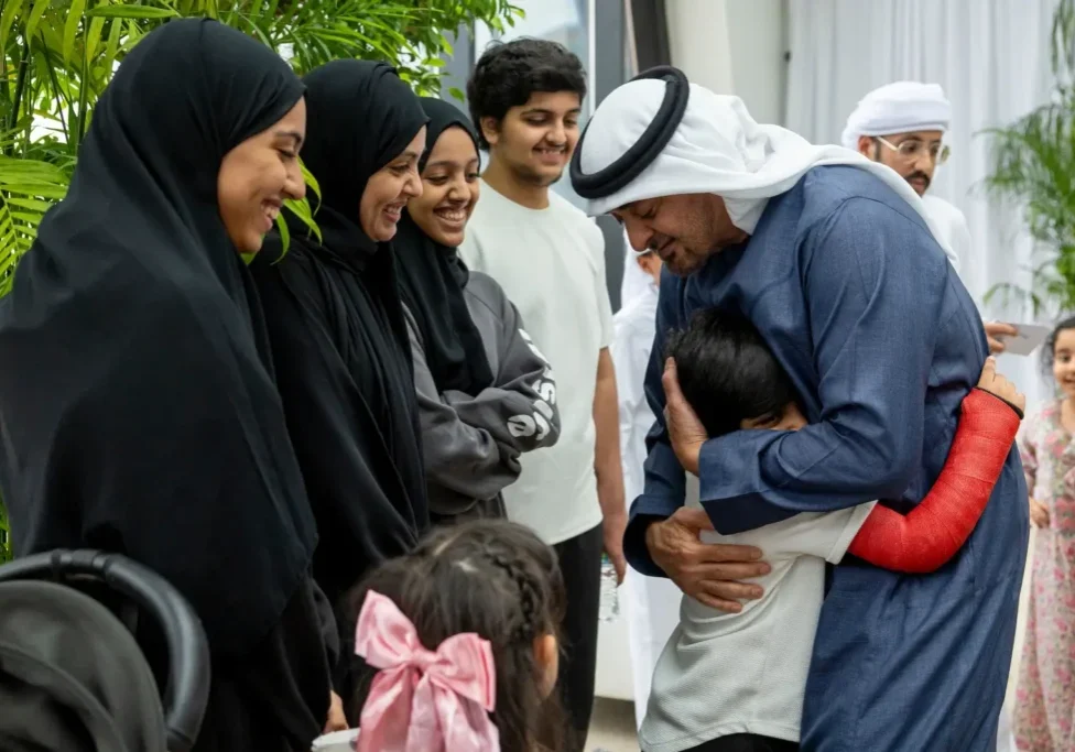 Man hugs child with arm in cast.