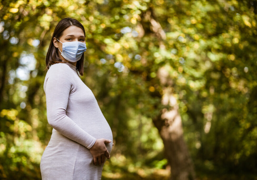 Portrait of pregnant woman in park in autumn.